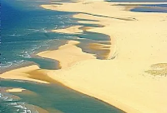 Vista aérea da Bacia de Arcachon mostrando bancos de areia dourados, águas turquesas e canais sinuosos ao longo da costa atlântica